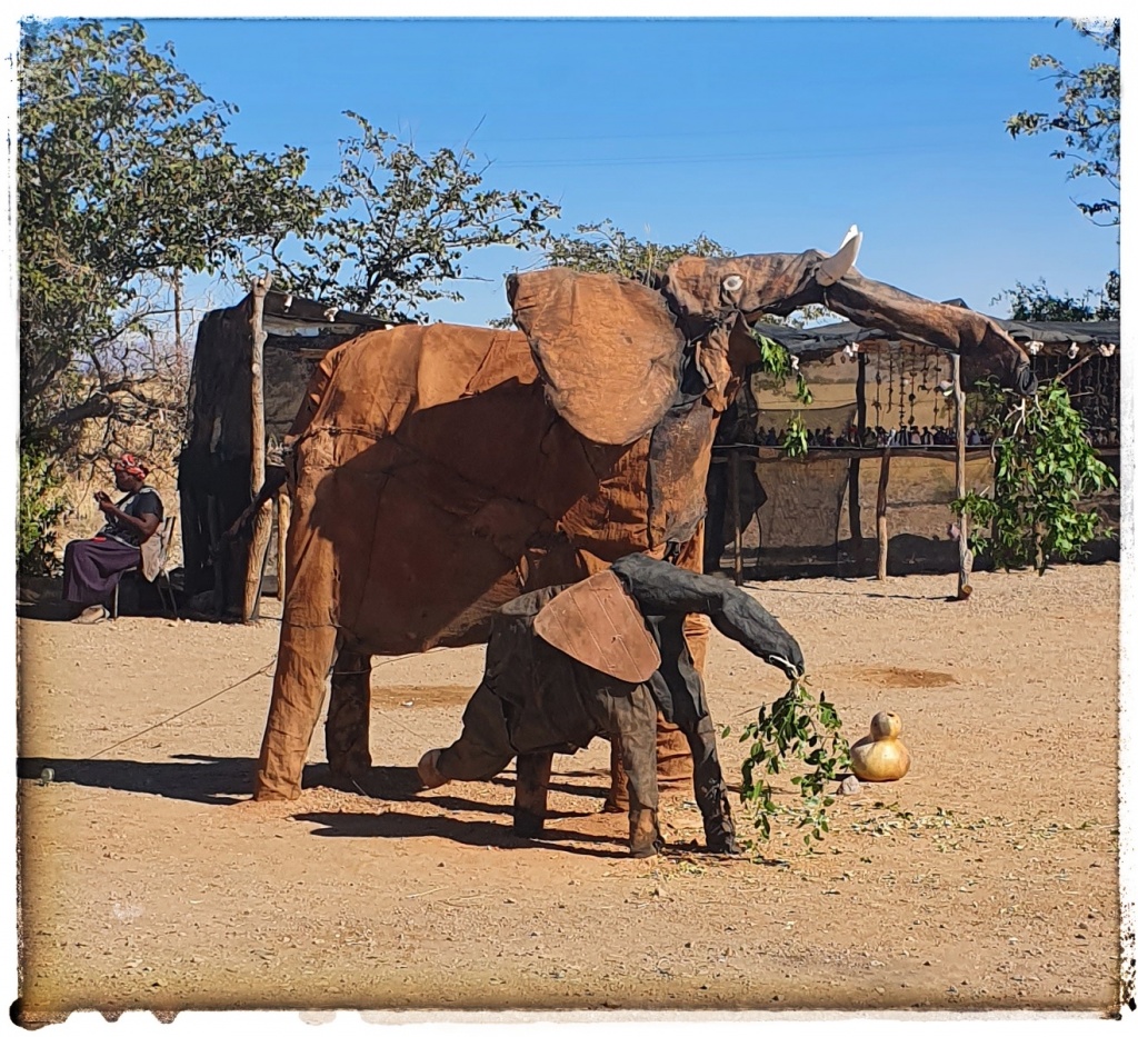 steel elephants operated by string , children hidden in the bushes